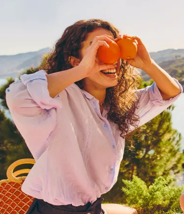 girl laying with oranges mobile