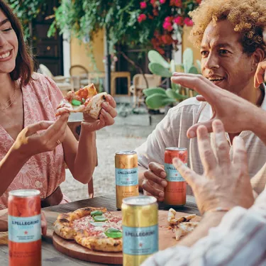 People dining outdoors with S.Pellegrino Essenza