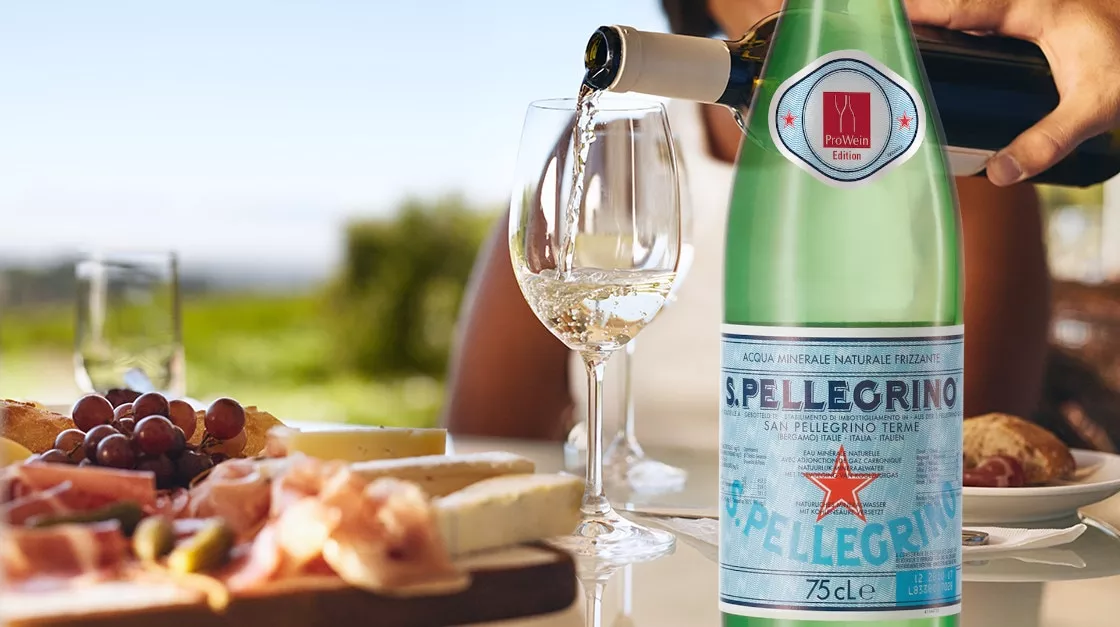 Gedeckter Tisch mit Weißwein und S.Pellegrino samt ProWein-Etikett 2020