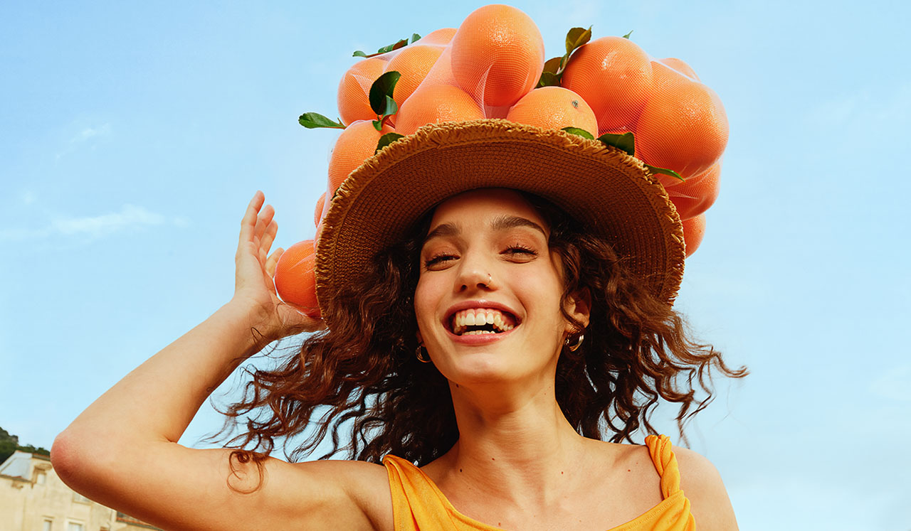 mujer sonriente con sombrero naranja
