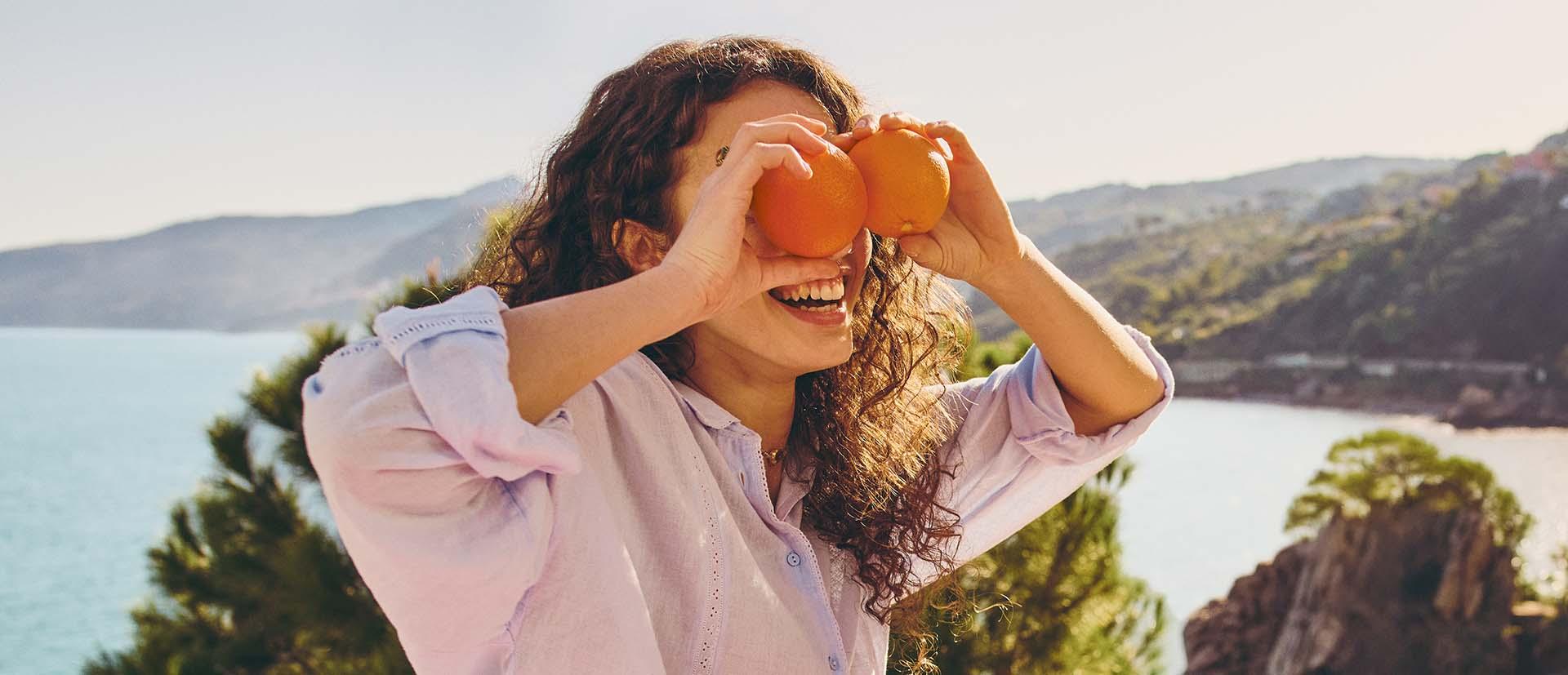 chica jugando con naranjas