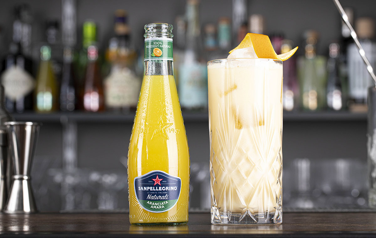 bicchiere di cocktail siciliano e bottiglia di aranciata amara naturali sanpellegrino
