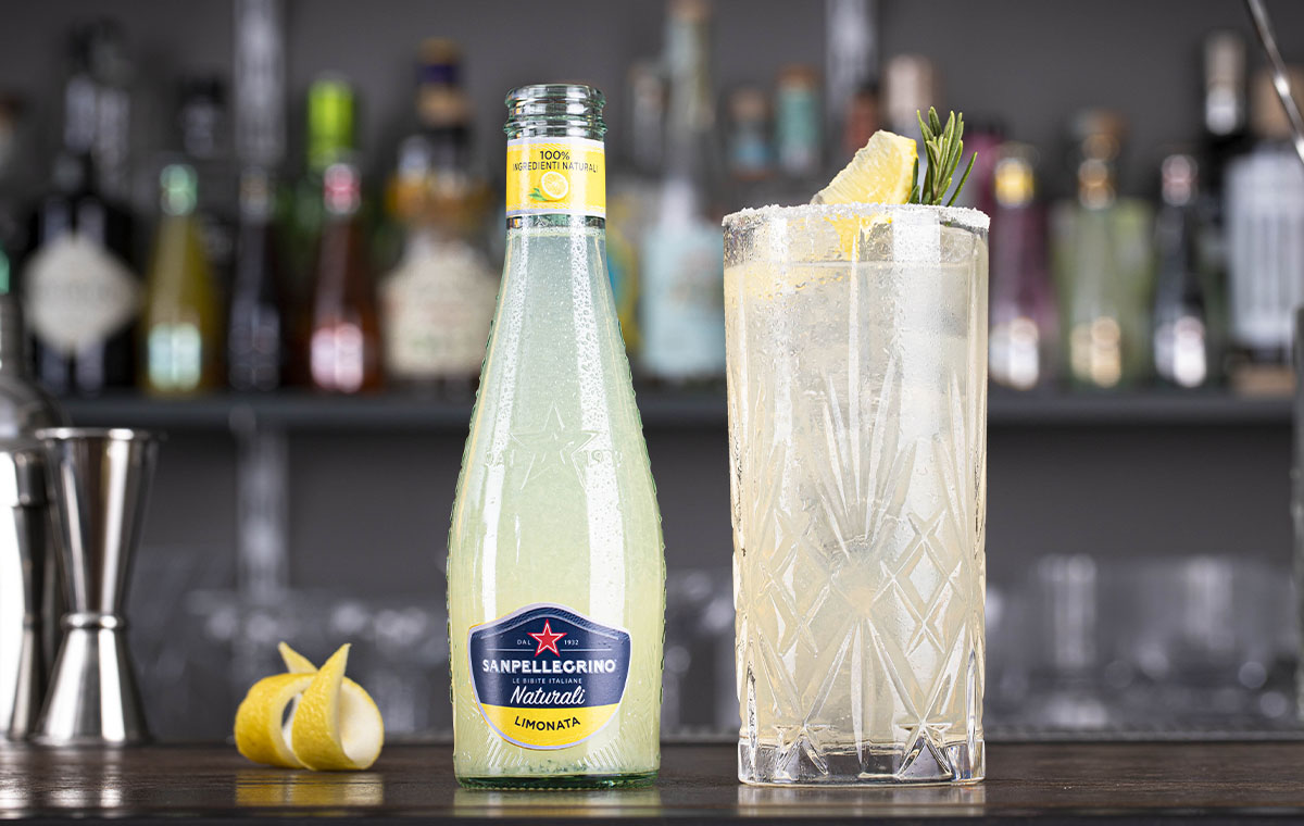 bicchiere di cocktail mediterraneo sour e bottiglia di limonata naturali sanpellegrino