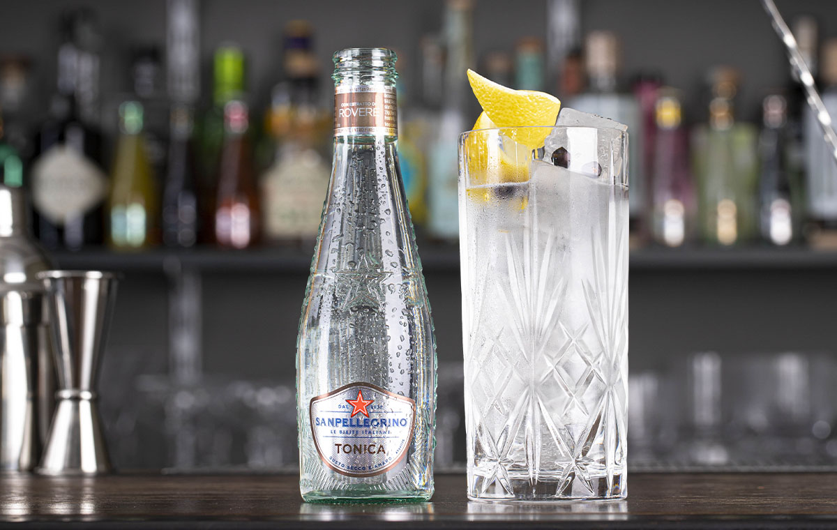 bicchiere con cocktail wood tonic e bottiglia di tonica rovere sanpellegrino