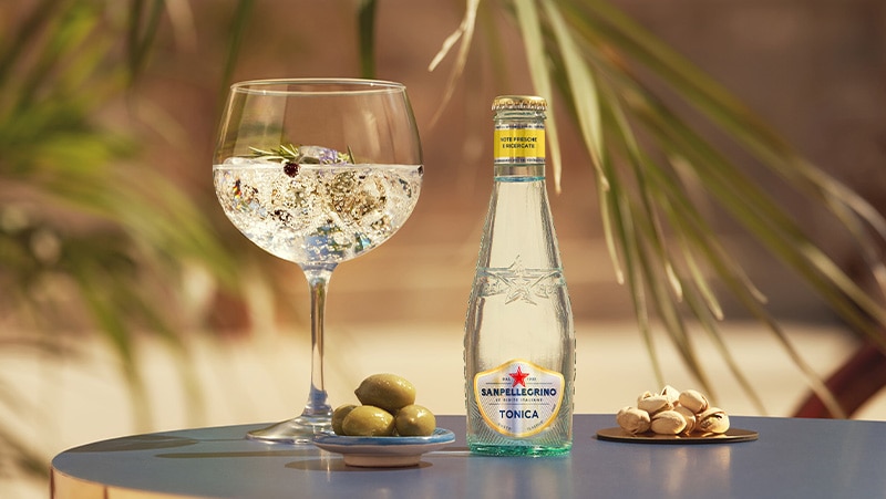 Tonica Gusto Classico con bicchiere di cocktail e olive