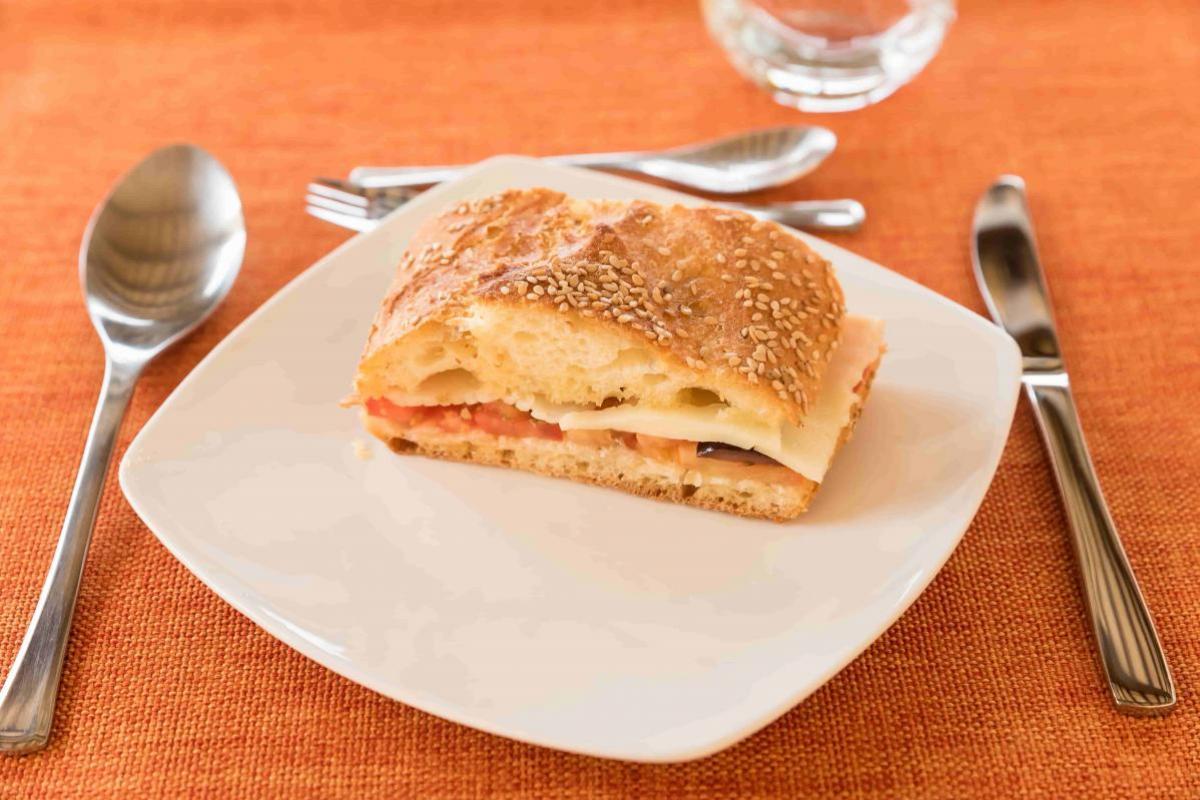 Pane cunzato con pomodori, cipolle, olive e formaggio