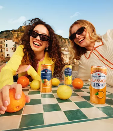 due ragazze sorridenti con bibite Sanpellegrino mobile
