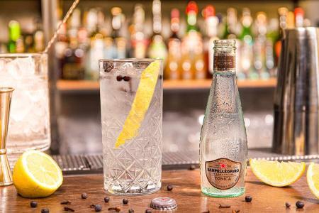 Bottiglia di Tonica Rovere Sanpellegrino con bicchiere di Wood Tonic accanto su bancone del bar