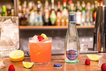 Bottiglietta di Gassosa Sanpellegrino con bicchiere di Sour Highball su bancone del bar