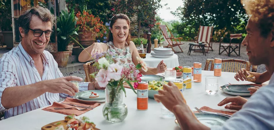 People dining outdoors with S.Pellegrino Essenza