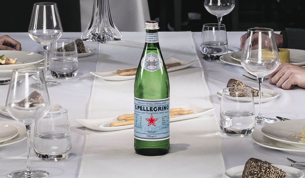 Botella de agua S.Pellegrino en vidrio sobre una mesa