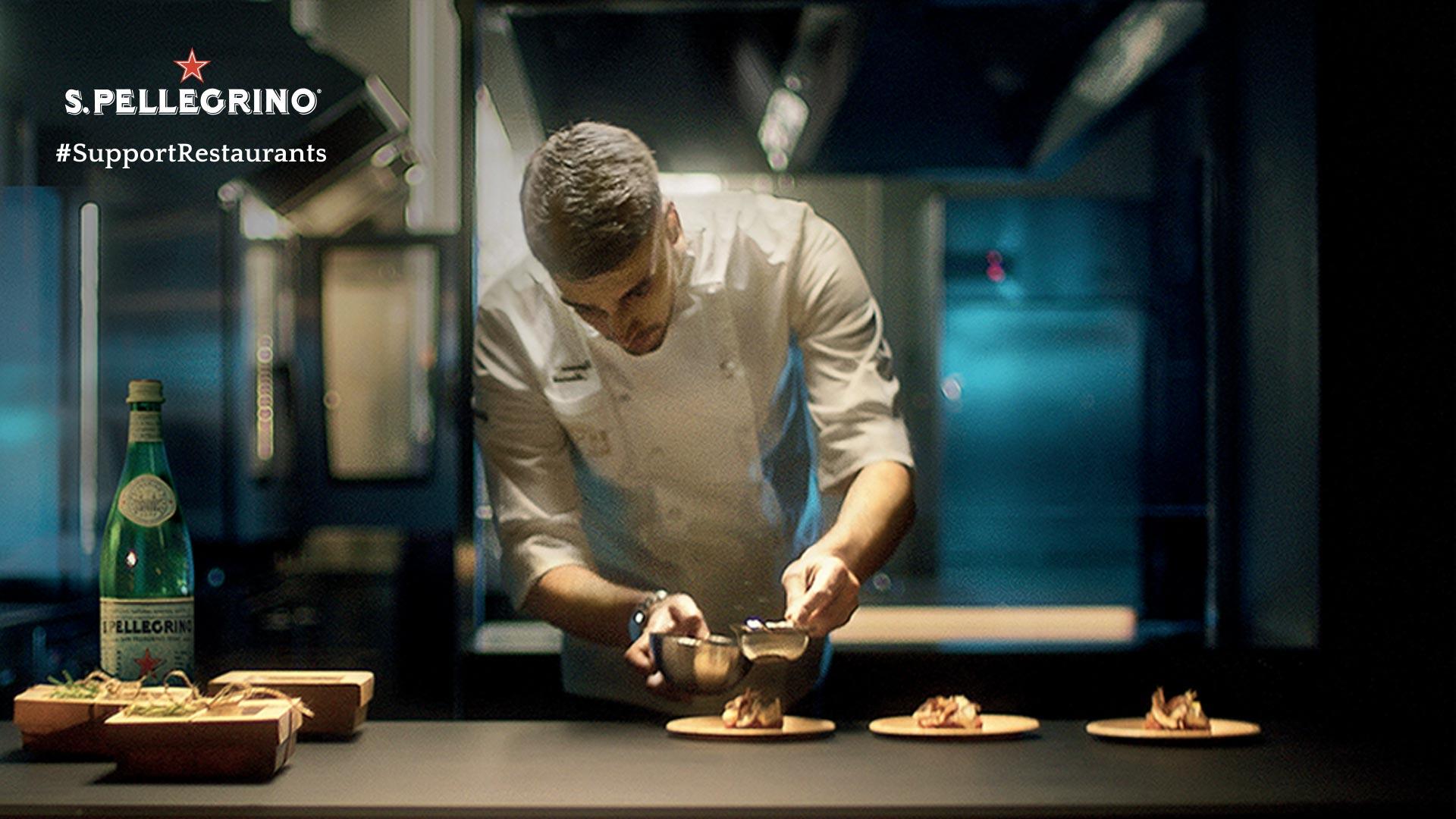 A chef dressed in white preparing a dish