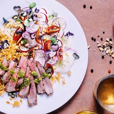 A plate of steak with fresh salad on rusty, stone background