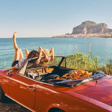 two girls relaxing on a convertible car