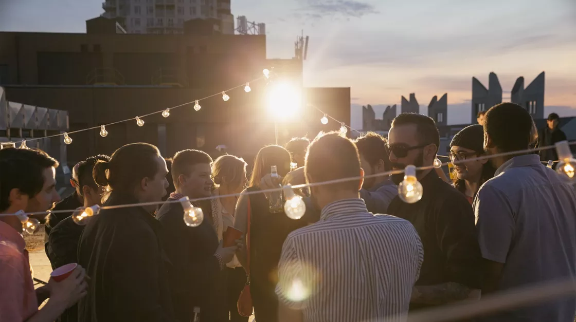 A party with some pending lights and people enjoying the sunset