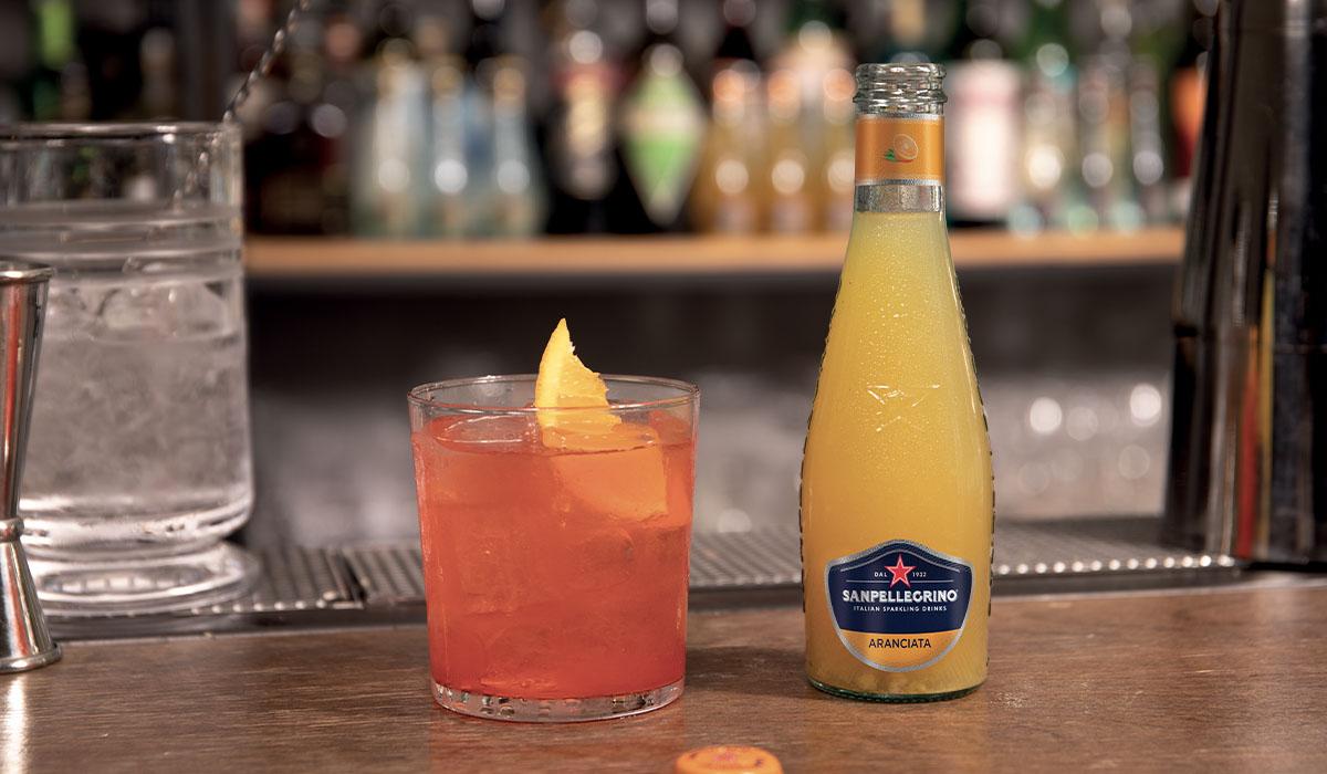 Sanpellegrino Garibaldi Cocktail with a bottle of Sanpellegrino Aranciata classic