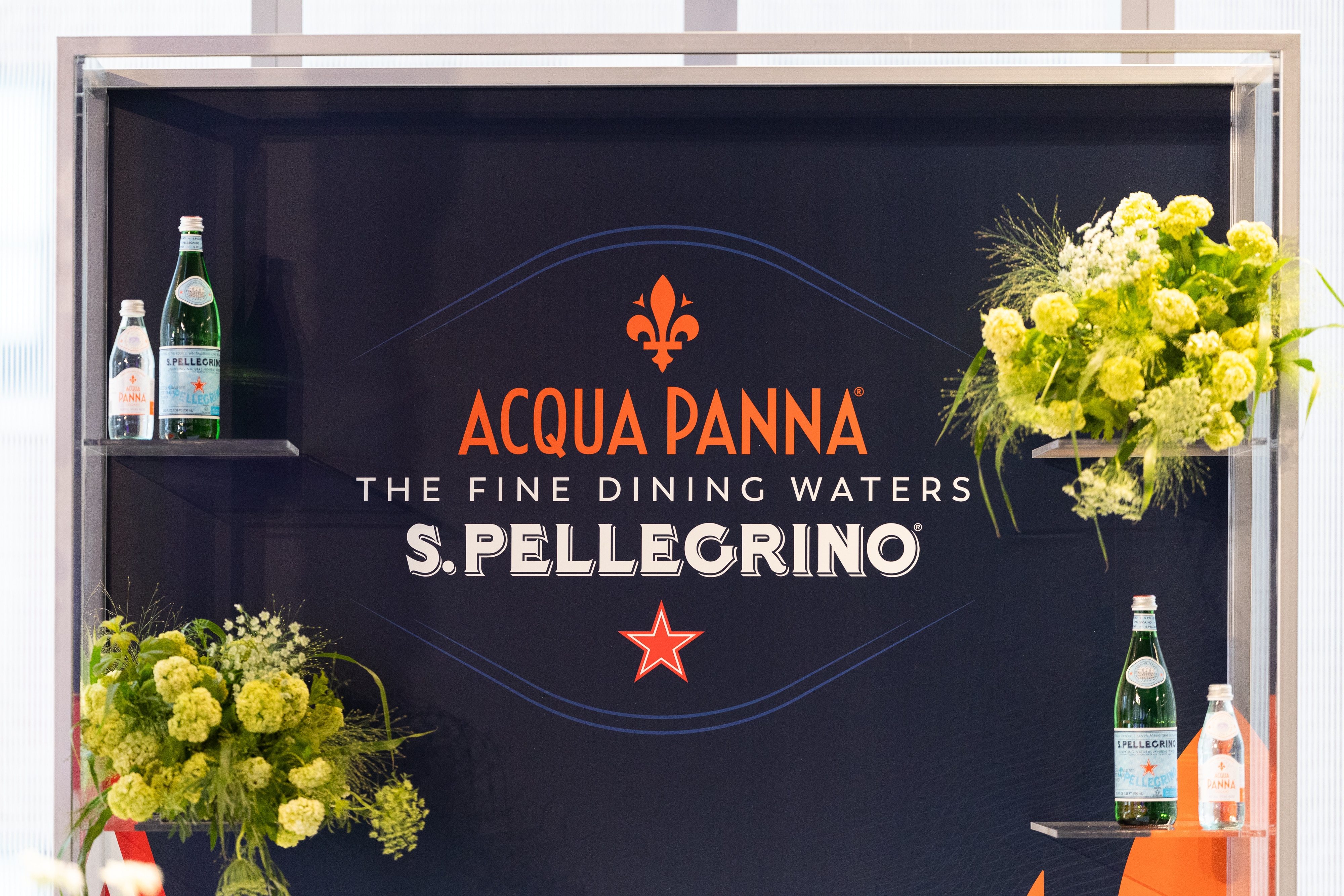 Acqua Panna and S.Pellegrino displayed in a sleek setup with flowers, promoting fine dining waters.
