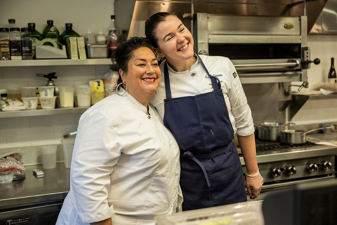 Chefs pose for the camera in a kitchen