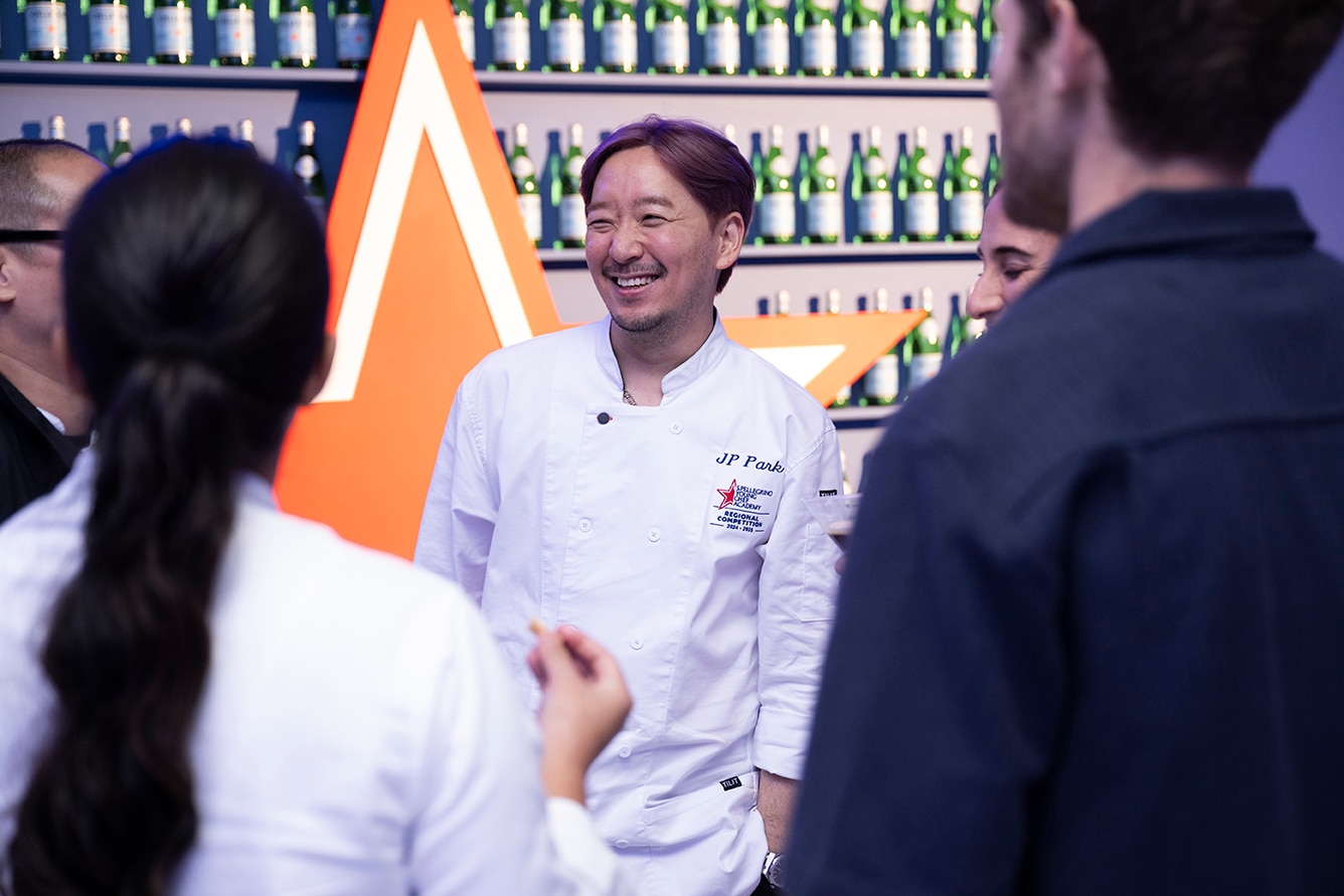 Chefs stand in front of a wall of green S.Pelligrino bottles