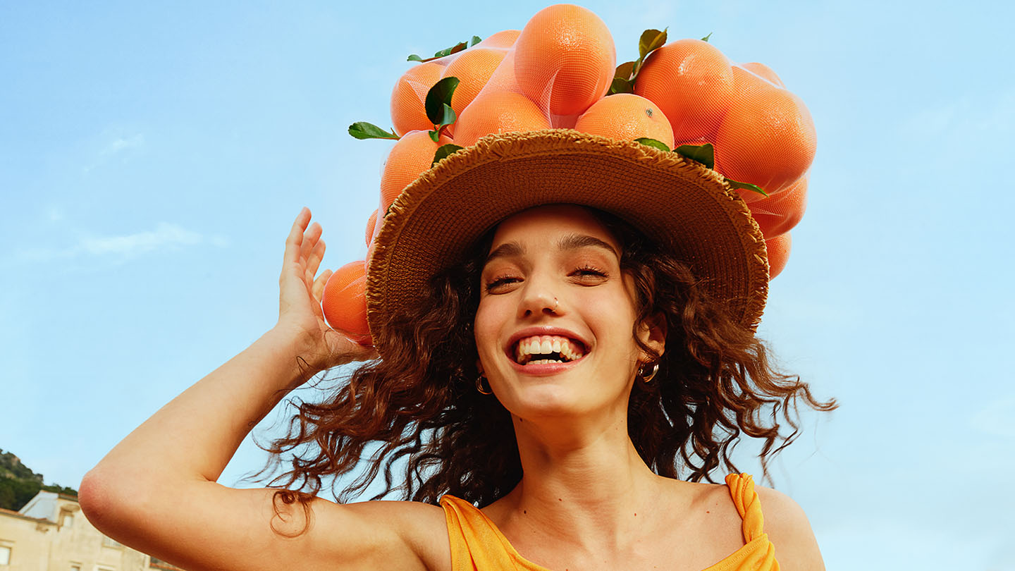 smiling woman with orange hat thumb home