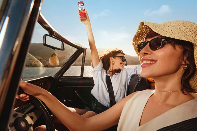 two happy girls in a convertible car with zero blood orange
