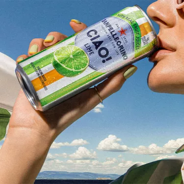 A girl sipping a can of Ciao! Lime flavor